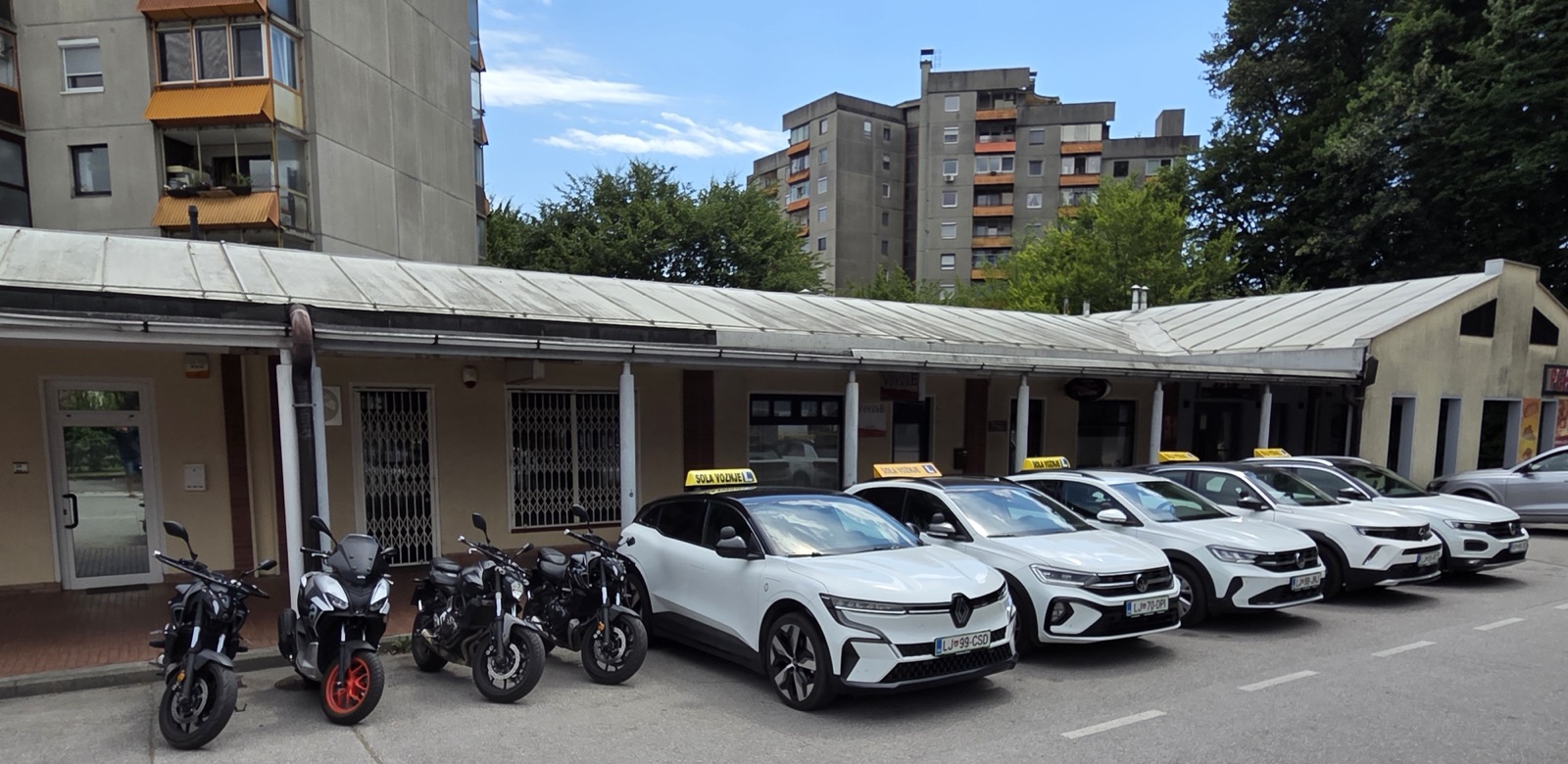 Flota vozil avtošole Voyage pred sedežem šole